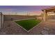 Backyard with artificial grass, covered patio and block wall at 17574 W Cardinal Dr, Goodyear, AZ 85338