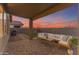 Covered patio with seating area and artificial turf at 17574 W Cardinal Dr, Goodyear, AZ 85338