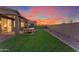 Spacious backyard with grassy lawn, patio furniture, and a view of the sunset at 17574 W Cardinal Dr, Goodyear, AZ 85338