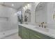 Modern bathroom with double vanity, green cabinets, and gold fixtures at 17574 W Cardinal Dr, Goodyear, AZ 85338