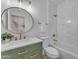 Elegant bathroom with a green vanity, round mirror, and white subway tile at 17574 W Cardinal Dr, Goodyear, AZ 85338