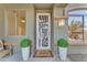 Inviting front entry with decorative door, potted plants, and a welcome mat at 17574 W Cardinal Dr, Goodyear, AZ 85338