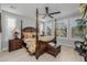 Relaxing bedroom with a four-poster bed, light wood floors, and plantation shutters at 17848 E Stocking Trl, Rio Verde, AZ 85263