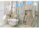 Bright bathroom featuring marble walls, a freestanding tub, a glass shower, and a mosaic tile floor at 19910 N 84Th St, Scottsdale, AZ 85255