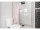 Modern bathroom with white and dark tile, shower, and toilet at 2037 E Riviera Dr, Tempe, AZ 85282