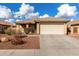 One-story house with beige exterior, attached garage, and landscaped front yard at 25700 W St James Ave, Buckeye, AZ 85326