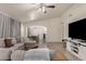 Spacious living room with L-shaped sectional sofa, hardwood floors, and large TV at 25700 W St James Ave, Buckeye, AZ 85326