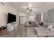 Bright living room featuring L-shaped sofa, hardwood floors, and a modern aesthetic at 25700 W St James Ave, Buckeye, AZ 85326