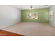 Living room features neutral carpeting, a ceiling fan and large windows at 26234 W Behrend Dr, Buckeye, AZ 85396
