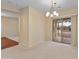 Bright living room with a view to the backyard pool through sliding glass doors and a chandelier at 26234 W Behrend Dr, Buckeye, AZ 85396