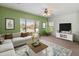 Spacious living room with large windows, stylish furniture, and a ceiling fan at 26234 W Behrend Dr, Buckeye, AZ 85396