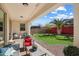 Covered patio and lush backyard, featuring grass, palm tree, and a cornhole game at 2901 E Iris Dr, Chandler, AZ 85286