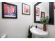 Elegant powder room with decorative art, a modern mirror, and a pedestal sink for guests at 2901 E Iris Dr, Chandler, AZ 85286