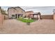 Wide backyard shot with stone landscaping, artificial turf, a gazebo and patio at 35598 N Murray Grey Dr, San Tan Valley, AZ 85143