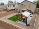 Private backyard featuring a covered patio, artificial turf, and charming outdoor seating area with pergola at 35598 N Murray Grey Dr, San Tan Valley, AZ 85143