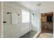 Bright bathroom features a glass shower, tiled walls, and an open doorway to a walk-in closet at 35598 N Murray Grey Dr, San Tan Valley, AZ 85143