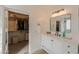 Bathroom featuring a vanity with sink, modern mirror, and a view into a walk-in closet at 35598 N Murray Grey Dr, San Tan Valley, AZ 85143