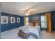 Cozy bedroom with blue walls, ceiling fan, stylish decor, and a comfortable-looking bed with decorative pillows at 35598 N Murray Grey Dr, San Tan Valley, AZ 85143