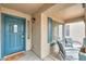 Cozy front porch features a blue front door, charming seating area, and lots of natural light at 35598 N Murray Grey Dr, San Tan Valley, AZ 85143