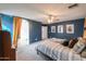 Comfortable main bedroom with carpet, blue walls, ceiling fan, and an en suite bathroom at 35598 N Murray Grey Dr, San Tan Valley, AZ 85143