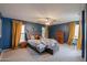 Spacious main bedroom with ample natural light, ceiling fan, blue accent wall, and carpet flooring at 35598 N Murray Grey Dr, San Tan Valley, AZ 85143