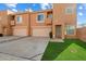 Tan two-story townhome with two-car garage and grassy yard at 3703 E Mitchell Dr, Phoenix, AZ 85018
