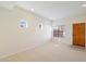 Bright and airy living room with neutral carpeting and wood door at 3703 E Mitchell Dr, Phoenix, AZ 85018