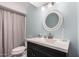 Bathroom with a round mirror and dark vanity at 4511 W Sandra Ter, Glendale, AZ 85306