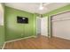 Bedroom with wood floors, green walls, and mounted TV at 4511 W Sandra Ter, Glendale, AZ 85306