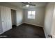 Well-lit bedroom featuring dark laminate flooring and a double-door closet at 4643 W Caron St, Glendale, AZ 85302