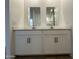 Bathroom featuring dual sinks with white cabinets, countertops, and modern hardware at 46905 W Old Timer Rd, Maricopa, AZ 85139