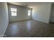 Large bedroom with wood look flooring and natural light from two windows at 46905 W Old Timer Rd, Maricopa, AZ 85139