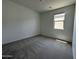 Bedroom showcasing neutral carpet, fresh paint, with window for natural light. Simple and clean design at 46905 W Old Timer Rd, Maricopa, AZ 85139