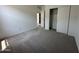 Bright bedroom showcasing plush carpeting, closet, neutral paint, open door and a view of the hallway at 46905 W Old Timer Rd, Maricopa, AZ 85139