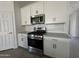 Modern kitchen with stainless steel appliances, white cabinets, neutral countertops, and tile backsplash at 46905 W Old Timer Rd, Maricopa, AZ 85139