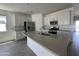 Bright kitchen features stainless steel appliances, white cabinets, an island and tile backsplash at 46905 W Old Timer Rd, Maricopa, AZ 85139