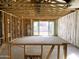 An interior framing of a living room showing the studs, insulation, and door to backyard at 46905 W Old Timer Rd, Maricopa, AZ 85139