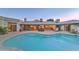 Backyard at dusk featuring a pool and spa surrounded by covered patio and lush landscaping at 5432 E Paradise Dr, Scottsdale, AZ 85254