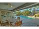 Covered patio with dining table overlooking refreshing pool and lush landscaping at 5432 E Paradise Dr, Scottsdale, AZ 85254