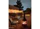 Relaxing backyard scene with a chiminea, comfy chairs, string lights, and lush landscaping at 6720 E Phelps Rd, Scottsdale, AZ 85254