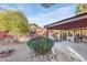 Lush backyard featuring desert landscaping, rock features, a covered patio and privacy wall at 6720 E Phelps Rd, Scottsdale, AZ 85254
