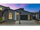 Charming modern home with a sleek garage door, neutral stucco, stone accents and desert landscaping at 6727 N 9Th Dr, Phoenix, AZ 85013