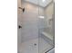 Modern shower with gray tile, a glass door, and a built-in bench at 6727 N 9Th Dr, Phoenix, AZ 85013