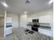 Modern kitchen with granite countertops and white cabinets at 9745 W Agora Ln, Tolleson, AZ 85353