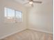 Bright bedroom with window, carpet flooring, and ceiling fan at 10036 W Parkway Rd, Tolleson, AZ 85353