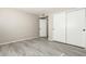 Bright bedroom featuring wood-look floors and double closets at 10436 W Devonshire Ave, Phoenix, AZ 85037