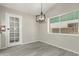 Dining area with gray vinyl flooring and an elegant chandelier at 10436 W Devonshire Ave, Phoenix, AZ 85037