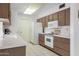 Galley style kitchen with wood cabinets and white appliances at 10737 W Hutton Dr, Sun City, AZ 85351