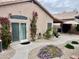 A home's exterior with a sliding glass door surrounded by flowering vines and desert landscaping at 1233 E Redfield Rd, Phoenix, AZ 85022