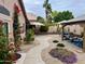 A serene backyard featuring desert landscaping, flowering vines, a gazebo, and an outdoor seating area at 1233 E Redfield Rd, Phoenix, AZ 85022